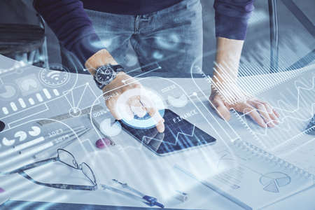 Double exposure of man's hands holding and using a digital device and tech theme hologram drawing. Technology concept.の写真素材
