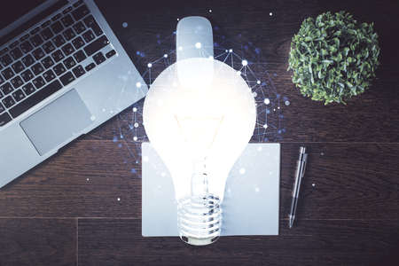 Bulb drawing over computer on the desktop background. Top view. Double exposure. Idea concept.の写真素材