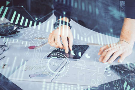 Double exposure of man's hands holding and using a digital device and tech theme hologram drawing....