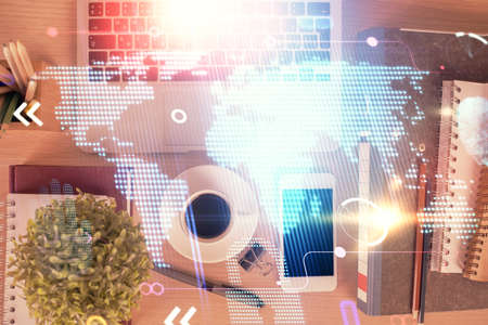 Double exposure of map hologram drawing over desktop. Top view. International connection concept.