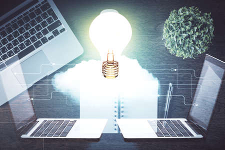 Bulb drawing over computer on the desktop background. Top view. Double exposure. Idea concept.