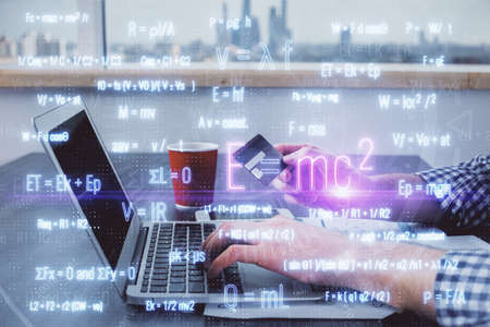 Double exposure of man hands holding a credit card and formula drawing. Education and E-commerce...