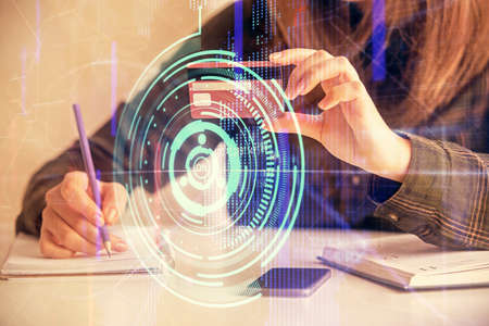 Double exposure of woman on-line shopping holding a credit card and data theme hologram drawing....