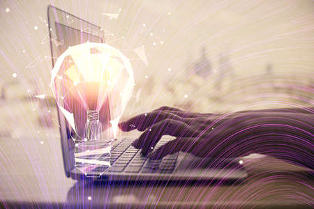 Double exposure of woman hands typing on computer and light bulb drawing. Idea concept.