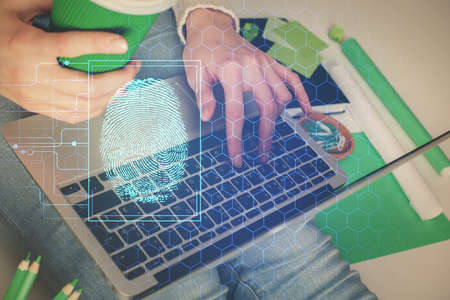 Double exposure of woman hands typing on computer and fingerprint drawing. Security concept.