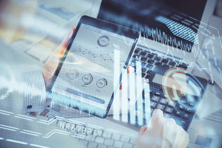 Double exposure of man's hands holding and using a digital device and tech theme hologram drawing....
