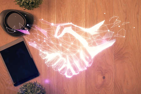 Multi exposure of handshake drawing over table with phone. Top view. Concept of partnership.の写真素材
