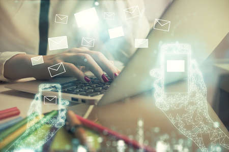 Double exposure of woman hands typing on computer and flying envelop drawing. E-Mail concept.の写真素材