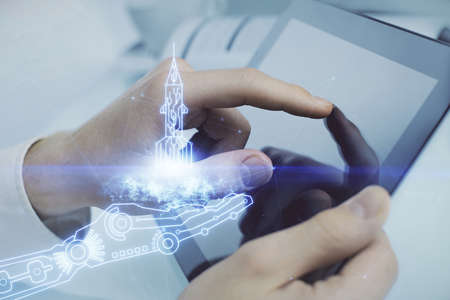 Double exposure of man's hands holding and using a mobile device and creative hologram drawing.