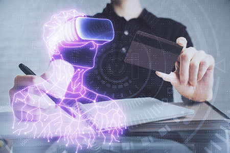 Double exposure of man hands holding a credit card and human in vr glasses drawing. Virtual reality...
