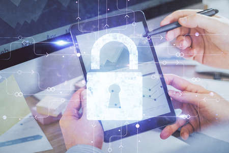 Multi exposure of man's hands holding and using a digital device and lock drawing. Security concept.
