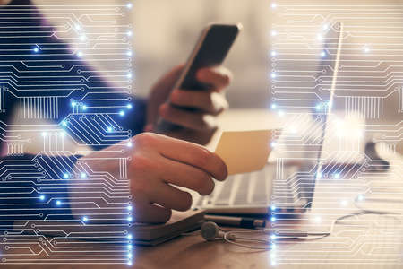 Double exposure of man's hands holding and using a digital device and tech theme hologram drawing. Technology concept.の写真素材