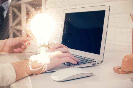 Double exposure of woman hands typing on computer and light bulb drawing. Idea concept.の写真素材