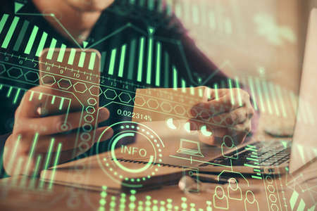 Double exposure of man's hands holding and using a digital device and tech theme hologram drawing....