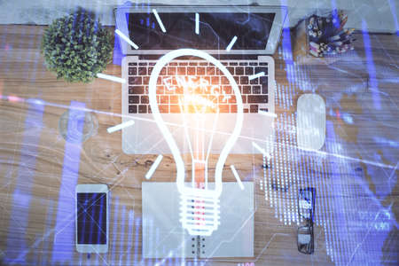 Bulb drawing over computer on the desktop background. Top view. Double exposure. Idea concept.の写真素材