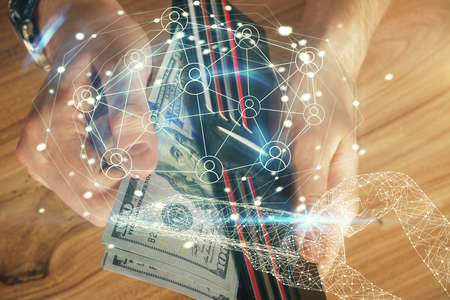 Multi exposure of social network theme drawing hologram and USA dollars bills and man hands.の写真素材