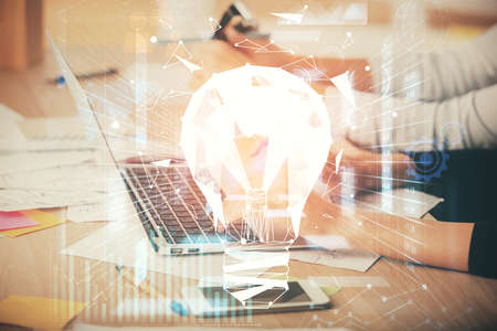 Double exposure of woman hands typing on computer and light bulb drawing. Idea concept.の写真素材