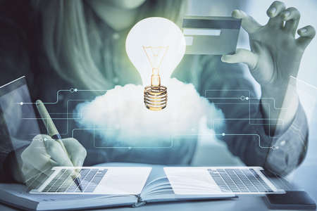 Multi exposure of woman on-line shopping holding a credit card and bulb drawing. Choice concept.