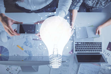 Double exposure of man and woman working together and bulb drawing. Computer background. Top View....