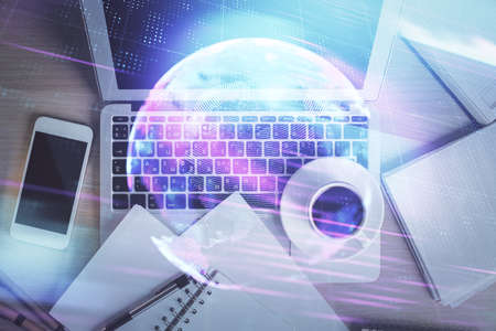 Technology hologram drawing over computer on the desktop background. Top view. Double exposure. Tech...