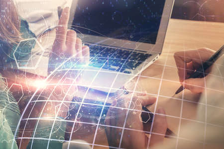 Double exposure of man and woman working together and technology theme world map drawing hologram....