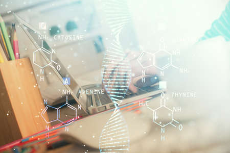Double exposure of woman hands typing on computer and DNA hologram drawing. Medical education concept.の写真素材