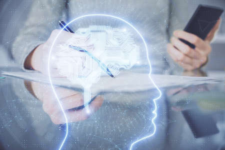 Double exposure of brain sketch hologram and woman holding and using a mobile device.