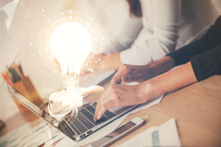 Double exposure of woman hands typing on computer and light bulb drawing. Idea concept.の写真素材