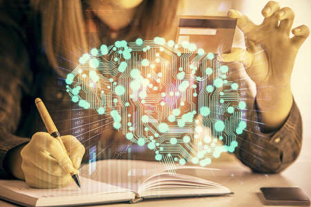 Double exposure of woman on-line shopping holding a credit card and brain hologram drawing. Data E-commerce concept.の写真素材
