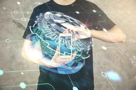 Double exposure of man's hand holding and using a digital device and data theme hologram drawing. Technology concept.の写真素材