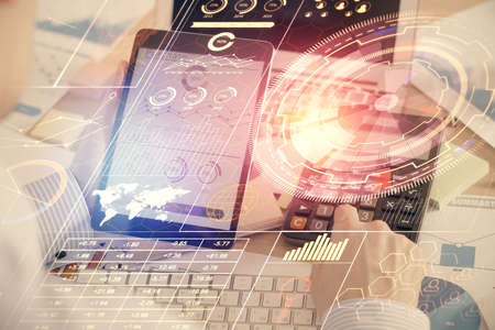 Double exposure of man's hand holding and using a digital device and data theme hologram drawing....