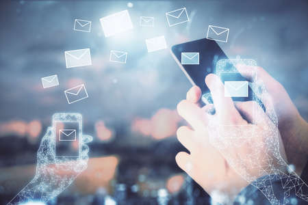 Double exposure of man's hands holding and using a digital device and envelop hologram drawing. E-mail concept.の写真素材