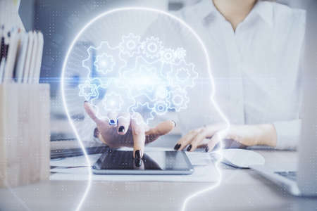 Double exposure of brain sketch hologram and woman holding and using a mobile device.