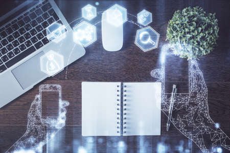 Technology hologram drawing over computer on the desktop background. Top view. Double exposure. Tech...