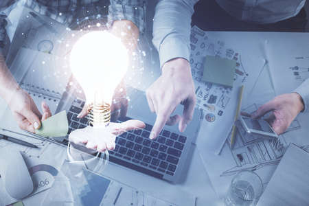 Double exposure of man and woman working together and bulb drawing. Computer background. Top View....