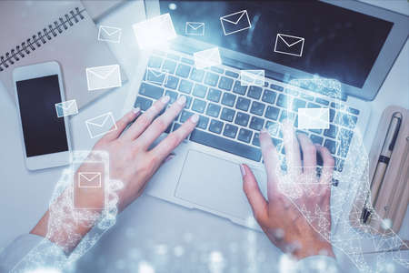 Double exposure of woman hands working on computer and envelop hologram drawing. Top View. E-mail concept.の写真素材