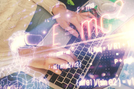 Double exposure of woman hands typing on computer and formula hologram drawing. Education concept.