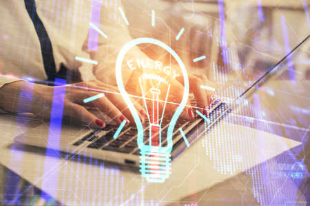 Double exposure of woman hands typing on computer and light bulb drawing. Idea concept.