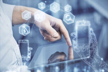 Double exposure of man's hands holding and using a digital device and tech theme hologram drawing....