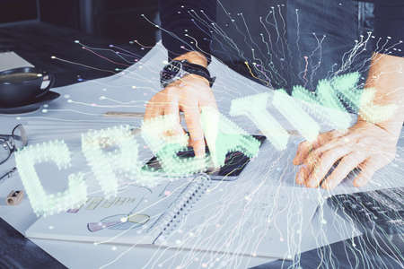 Double exposure of man's hands holding and using a mobile device and creative hologram drawing.