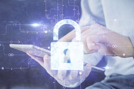 Multi exposure of man's hands holding and using a digital device and lock drawing. Security concept.の写真素材