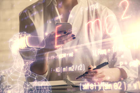 Double exposure of formulas sketch hologram and woman holding and using a mobile device. Education...