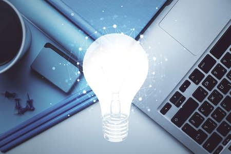 Bulb drawing over computer on the desktop background. Top view. Double exposure. Idea concept.