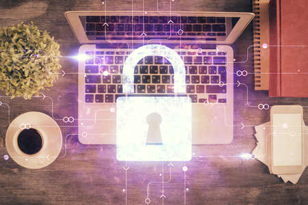 Double exposure of lock hologram drawing over study table background with computer. Concept of data...