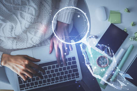 Double exposure of woman hands working on computer and creative hologram drawing. Top View. Start up concept.の写真素材