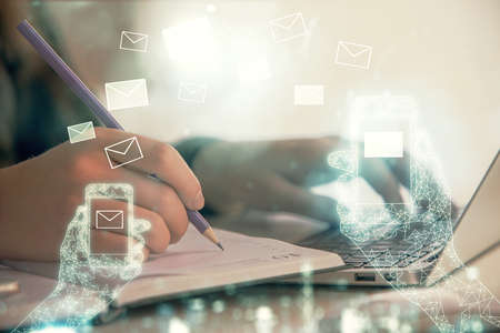 Double exposure of woman hands typing on computer and flying envelop drawing. E-Mail concept.の写真素材