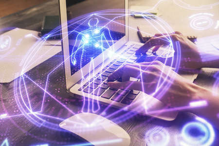 Double exposure of woman hands typing on computer and general theme hologram drawing. Education...