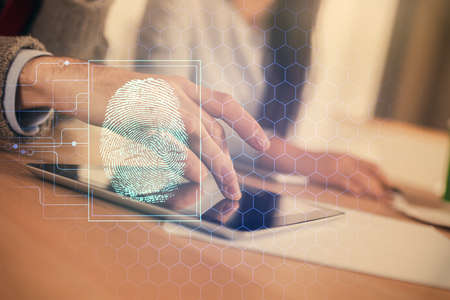Double exposure of fingerprint hologram and man and woman working together holding and using a...