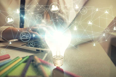 Double exposure of woman hands typing on computer and light bulb drawing. Idea concept.の写真素材