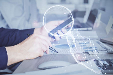Double exposure of man's hands holding and using a mobile device and creative hologram drawing.の写真素材